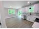 Modern kitchen boasts new white cabinets, quartz counters and new appliances, next to a combined living area at 608 E Umstead St, Durham, NC 27701