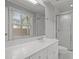 Bright bathroom with a skylight, white vanity, and shower with glass door at 6605 Huntingridge Rd, Chapel Hill, NC 27517