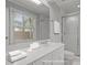 Bright white bathroom with vanity, shower, and natural light streaming through the window at 6605 Huntingridge Rd, Chapel Hill, NC 27517