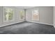 Spacious empty bedroom with three large windows and neutral carpeting at 6605 Huntingridge Rd, Chapel Hill, NC 27517