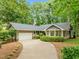 Charming single-story home boasts a well-manicured lawn and a winding driveway leading to a two-car garage at 6605 Huntingridge Rd, Chapel Hill, NC 27517