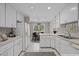 Bright eat-in kitchen with white cabinetry, modern appliances, and stainless steel sink at 6605 Huntingridge Rd, Chapel Hill, NC 27517