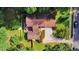 Aerial perspective of the home showing the layout, driveway, backyard deck, and surrounding landscape with lush greenery at 6701 Winding Trail Trl, Raleigh, NC 27612