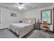 Well-lit bedroom with a large bed, plush carpet, neutral walls, and a ceiling fan at 6701 Winding Trail Trl, Raleigh, NC 27612