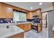 Bright kitchen featuring stainless steel appliances, granite countertops, and wood cabinets with navy backsplash at 6701 Winding Trail Trl, Raleigh, NC 27612