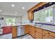 Well-lit kitchen with stainless steel appliances, granite countertops, wooden cabinets, and a view into the adjacent living area at 6701 Winding Trail Trl, Raleigh, NC 27612