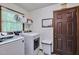Well-organized laundry room equipped with modern washer and dryer, storage shelves, and a convenient exterior door at 6701 Winding Trail Trl, Raleigh, NC 27612