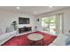Comfortable living room with a large flat-screen TV, cozy seating, and sliding glass doors leading to the outdoor deck at 6701 Winding Trail Trl, Raleigh, NC 27612