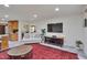 Inviting living room featuring a large flat-screen TV, neutral-toned sofas, and seamless open-plan access to the kitchen at 6701 Winding Trail Trl, Raleigh, NC 27612
