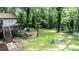 Large backyard with mature trees, featuring a deck, stone pavers, and a charming hammock at 7016 Valley Dr, Raleigh, NC 27612