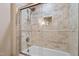 Shower featuring neutral tile, glass doors, and a built-in niche for toiletries at 7016 Valley Dr, Raleigh, NC 27612