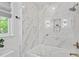 Bathroom featuring marble tile, glass enclosed shower with niche, and spa tub at 7016 Valley Dr, Raleigh, NC 27612