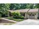 Charming home featuring a well-manicured lawn, mature trees, and a convenient attached garage at 7016 Valley Dr, Raleigh, NC 27612