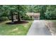 Residential home featuring a well-maintained lawn and landscaping, accented by mature trees and an attached garage at 7016 Valley Dr, Raleigh, NC 27612