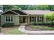 Welcoming entrance with wood door and seasonal decor, complemented by a cozy chair and well-kept landscaping at 7016 Valley Dr, Raleigh, NC 27612