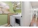 Efficient laundry room featuring modern washer and dryer, with built-in shelves at 7016 Valley Dr, Raleigh, NC 27612