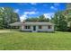 Inviting single-story home featuring a manicured lawn, a blue front door, and attached carport at 802 Creech Church Rd, Kenly, NC 27542