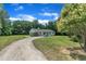 View of a home with gravel driveway and mature trees at 802 Creech Church Rd, Kenly, NC 27542