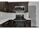 A kitchen featuring stainless steel appliances, dark cabinets, and white countertops at 802 Creech Church Rd, Kenly, NC 27542