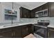 Modern kitchen with stainless steel appliances, quartz countertops, dark cabinets and a glass tile backsplash at 802 Creech Church Rd, Kenly, NC 27542