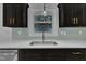 Close up on the kitchen sink featuring modern faucet, stainless steel appliances, white countertops and dark cabinetry at 802 Creech Church Rd, Kenly, NC 27542