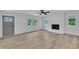 Bright living room with wood-look flooring, lots of windows, ceiling fan and a painted brick fireplace at 802 Creech Church Rd, Kenly, NC 27542