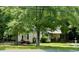 Charming single-story home with a covered porch, surrounded by mature trees and a red motorcycle at 981 Leasburg Rd, Roxboro, NC 27573