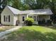 Cozy one-story home with a metal roof, charming front porch, and small, landscaped yard at 981 Leasburg Rd, Roxboro, NC 27573