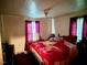 Simple bedroom features one bed, window with red curtains and white walls at 981 Leasburg Rd, Roxboro, NC 27573