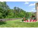 Expansive backyard with lush green grass, wooden fence, and outdoor entertainment area at 1154 Yorkshire Dr, Burlington, NC 27215