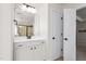 Modern bathroom showcasing a white vanity with black hardware, a large mirror and a view to the shower at 1154 Yorkshire Dr, Burlington, NC 27215