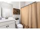 Bathroom featuring a sink, toilet, wooden shelving, and burlap shower curtain at 1154 Yorkshire Dr, Burlington, NC 27215