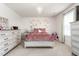 Bedroom featuring a crystal chandelier, plush pink bedding, decorative art, and multiple windows at 1154 Yorkshire Dr, Burlington, NC 27215