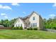 Beautiful home boasts lush green lawn, mature trees, and a classic facade under a sunny sky at 1154 Yorkshire Dr, Burlington, NC 27215