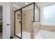 Tiled shower with glass enclosure, built in shelves, and adjacent soaking tub under a bright window at 1154 Yorkshire Dr, Burlington, NC 27215