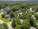 An aerial shot highlights the neighborhood, showcasing the house among tree-lined streets and manicured lawns in a serene setting at 116 Lost Tree Ln, Cary, NC 27513