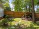 A tranquil backyard with lush greenery, a wooden fence, a decorative birdhouse, and a cozy bench area creates an ideal retreat at 116 Lost Tree Ln, Cary, NC 27513