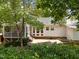 A serene backyard featuring a brick patio, a screened-in porch, manicured greenery, and mature trees offering shade and seclusion at 116 Lost Tree Ln, Cary, NC 27513