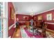 Elegant dining room featuring red walls, chandelier, and hardwood floors at 116 Lost Tree Ln, Cary, NC 27513