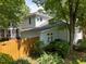 Exterior shot of a two-story house with a wooden fence, green shrubs, and mature trees adding to its curb appeal at 116 Lost Tree Ln, Cary, NC 27513