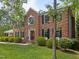 Beautiful two-story brick home with dark shutters, well-manicured front yard, and lush landscaping at 116 Lost Tree Ln, Cary, NC 27513