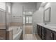 Bright bathroom with double sink vanity, soaking tub with tile surround, and view to a bedroom at 1172 Pemberly Ave, Morrisville, NC 27560