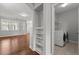 A laundry room near a well-lit living space showcasing modern appliances and built in shelving at 1172 Pemberly Ave, Morrisville, NC 27560