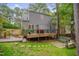 Spacious backyard with a wooden deck, patio area, and lush greenery at 1302 Valley Run Dr, Durham, NC 27707