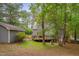 Expansive backyard featuring a deck, storage shed, and mature trees at 1302 Valley Run Dr, Durham, NC 27707