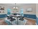 Elegant dining area with wainscoting, modern chandelier, and bright natural light at 1302 Valley Run Dr, Durham, NC 27707