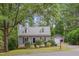 View of a well-maintained home, detached garage, and driveway amid mature trees at 1302 Valley Run Dr, Durham, NC 27707