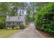 Charming gray home with dormer windows, a detached garage, and a long driveway lined with mature trees at 1302 Valley Run Dr, Durham, NC 27707