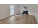 Spacious room with a fireplace and hardwood flooring, complemented by a large window at 1302 Valley Run Dr, Durham, NC 27707