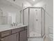 Bathroom featuring marble vanity, glass enclosed shower, neutral tile, and dark brown cabinets at 132 Cotten Dr, Morrisville, NC 27560